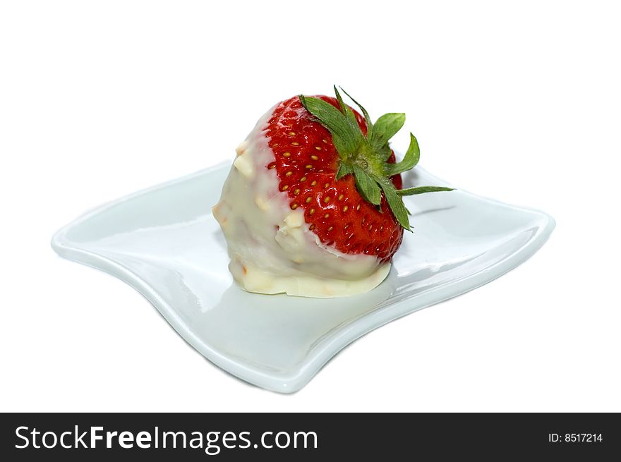 Strawberry dipped in white chocolate and nuts on a tiny plate, white background, studio shot