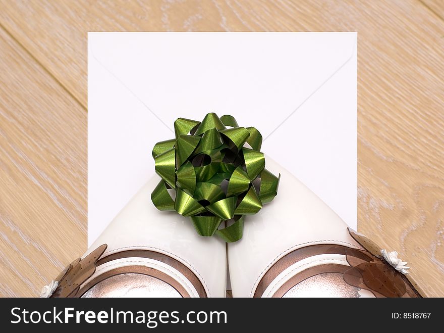 An envelope with a letter and a green bow left behind by the white shoes. An envelope with a letter and a green bow left behind by the white shoes
