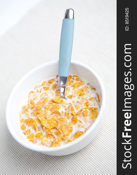 Milk and cornflakes on the white background