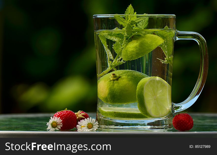 Green Round Fruit on Clear Glass Mug With Water