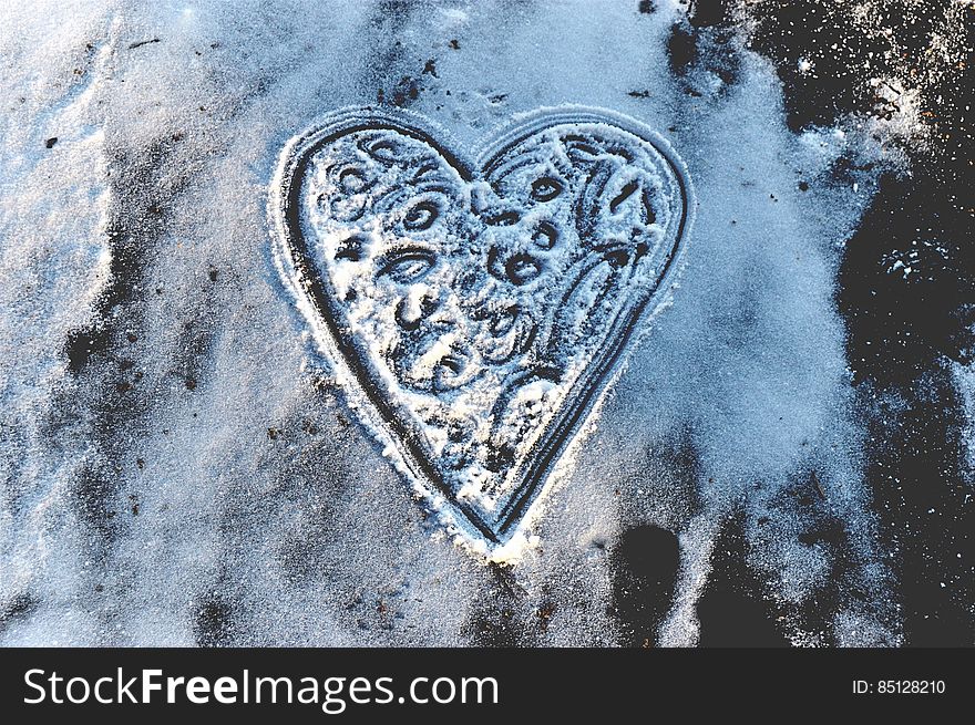 A heart drawn in snow on an icy surface. A heart drawn in snow on an icy surface.