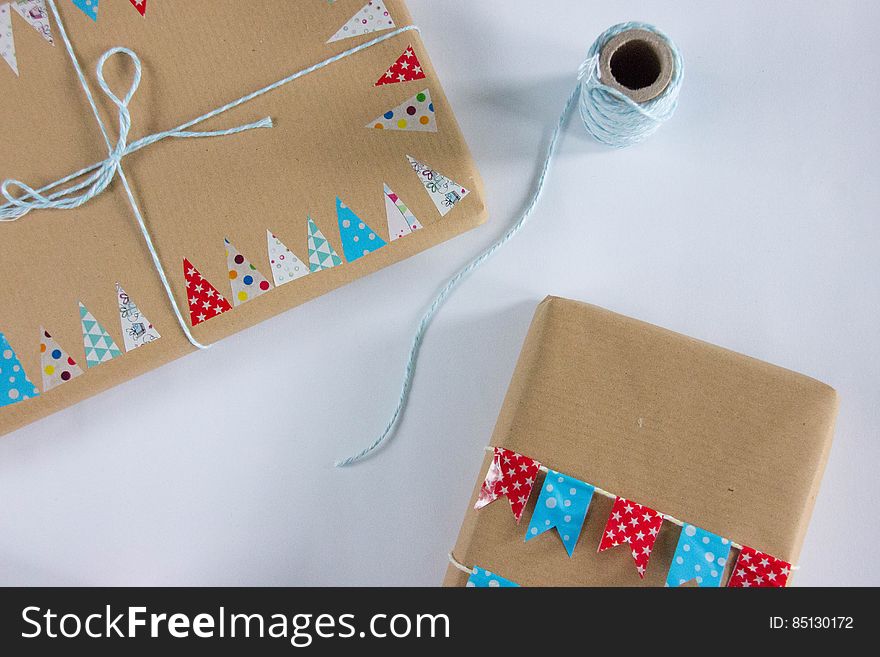 A pair of Christmas presents wrapped in brown paper tied with string.