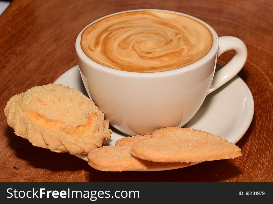 A cup of cappuccino coffee and sweet cookies. A cup of cappuccino coffee and sweet cookies.