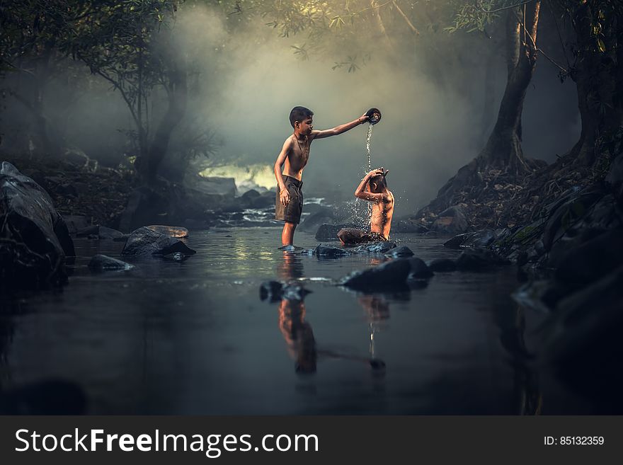 A pair of boys washing in the river. A pair of boys washing in the river.