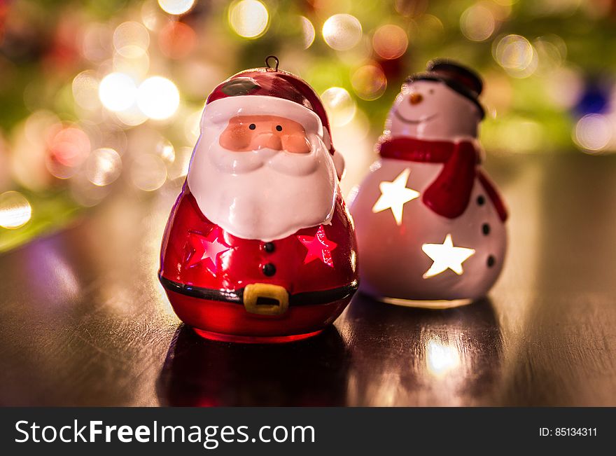 Santa Claus and Frosty ornaments on blurred background