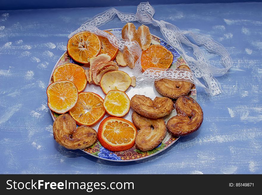 He Mandarin slices, biscuits in the form of hearts on a blue background with lace and bow. He Mandarin slices, biscuits in the form of hearts on a blue background with lace and bow.