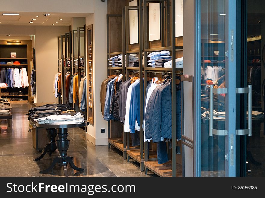 Interior of boutique clothing store with hanger and shelf displays.