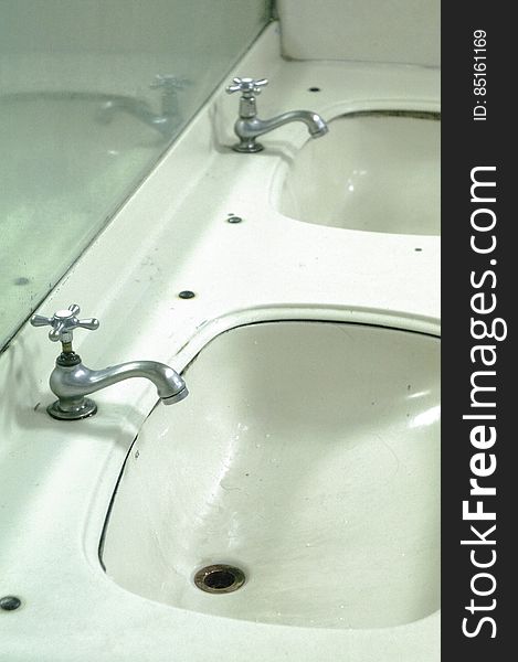 Metal faucets in porcelain sinks. Metal faucets in porcelain sinks.