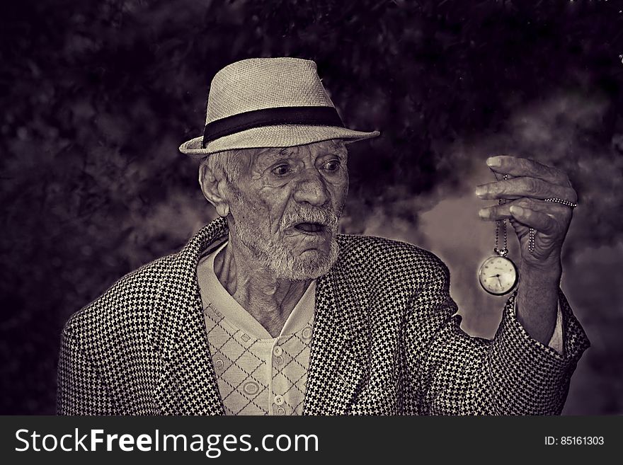 Man Holding Pocket Watch in Grayscale