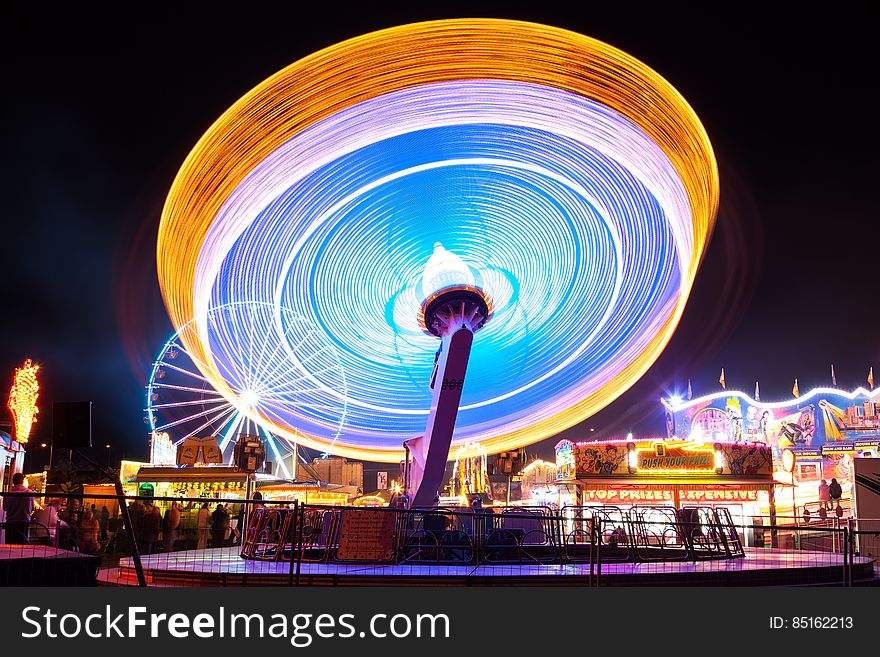 A long exposure of a spinning carousel in an amusement park. A long exposure of a spinning carousel in an amusement park.