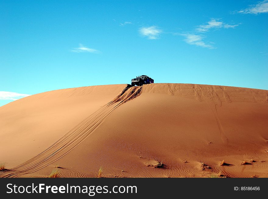 Car On Top Of Sand Cliff During Day Time