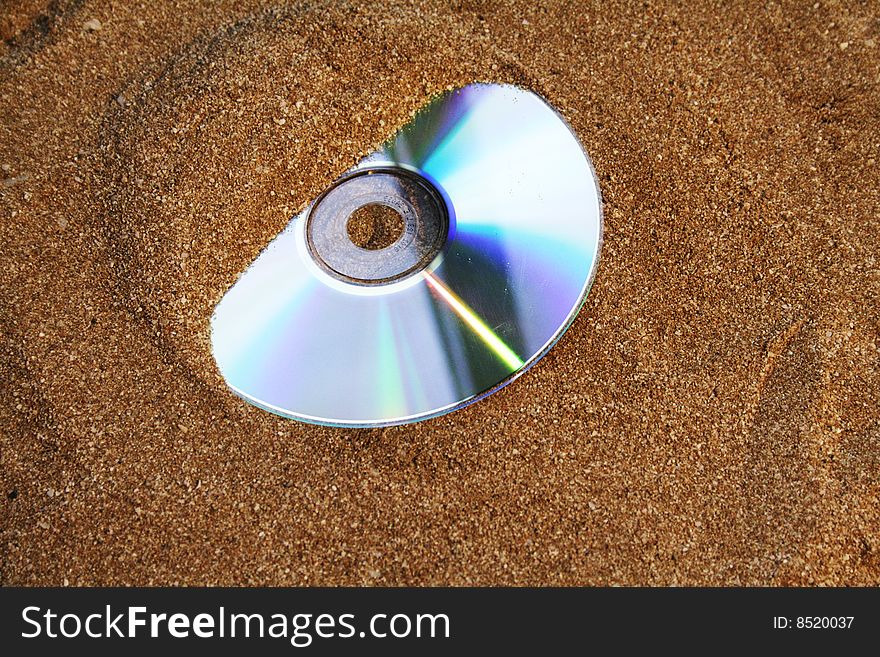 Cd half covered with sand.