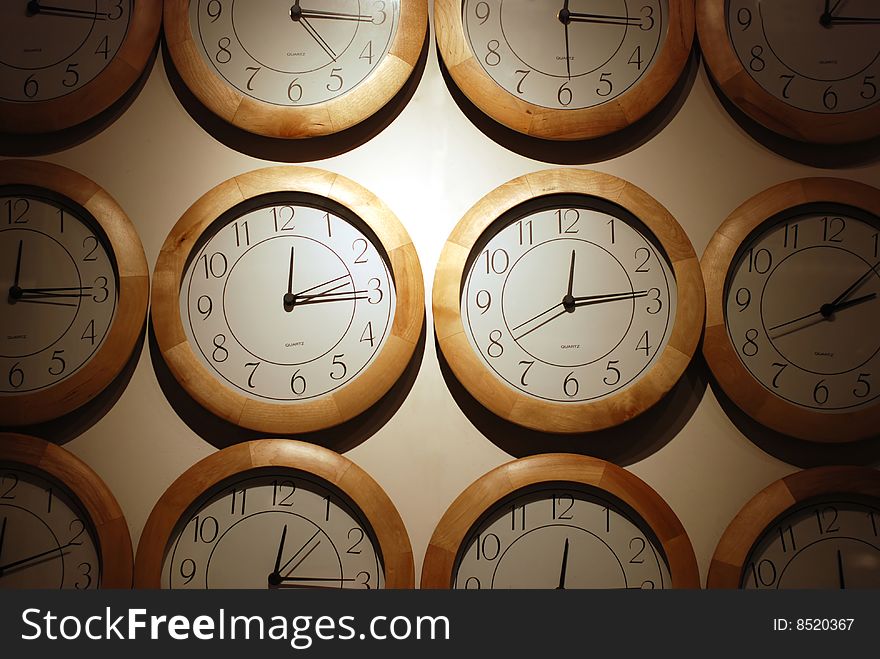 Clock faces arranged on white wall