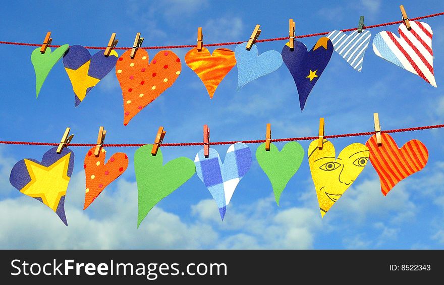 Textile hearts with a smiling face on a clothesline. Textile hearts with a smiling face on a clothesline