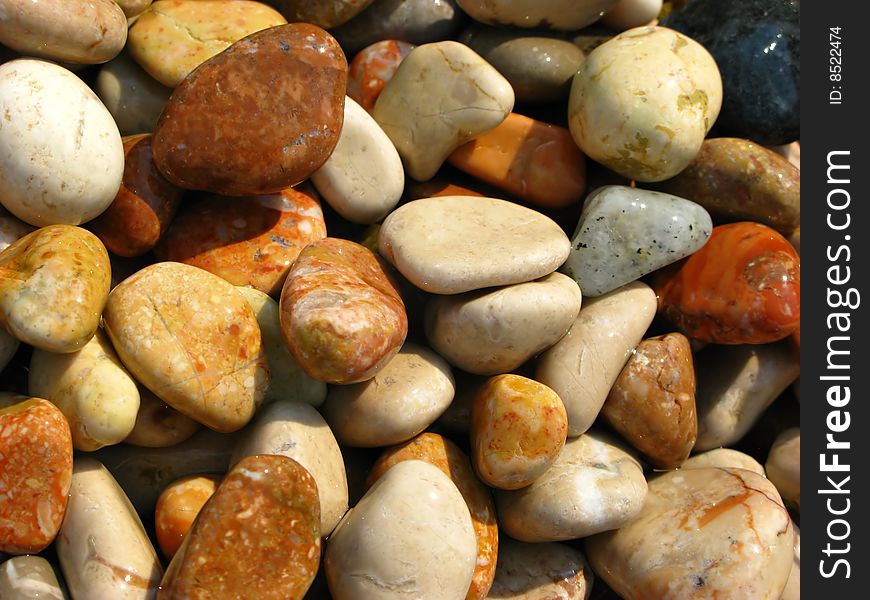 Beautiful decorative background from sea stones covered by  sunlight