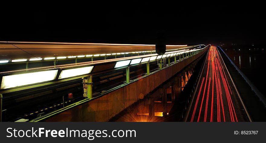 Subway-motor bridge at night with motion traces of cars and train. Subway-motor bridge at night with motion traces of cars and train