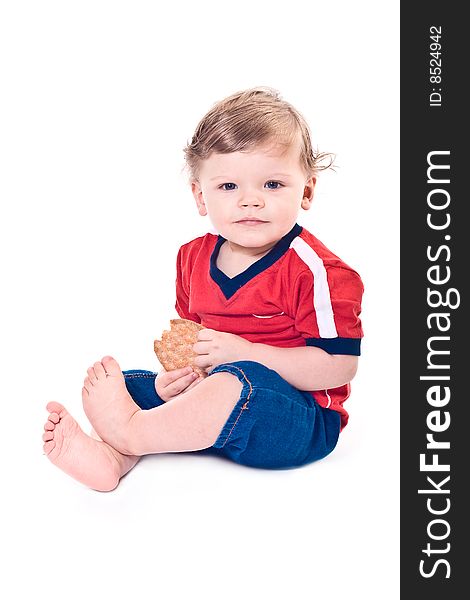 Little baby sits with cookies in hands on white background