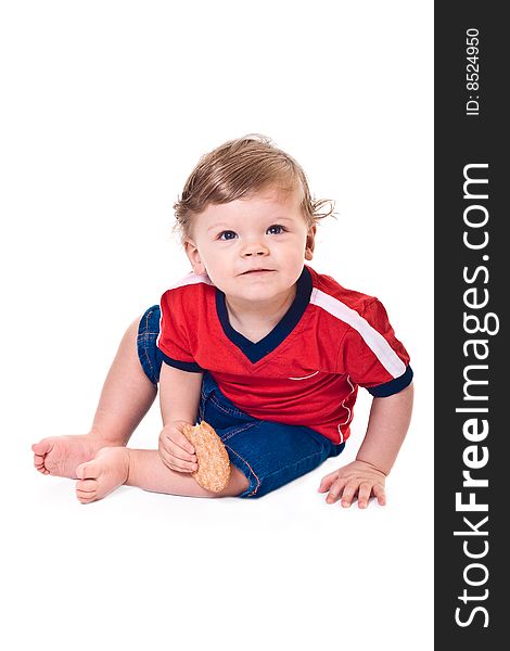 Curious baby crawls with cookies in hand on white background