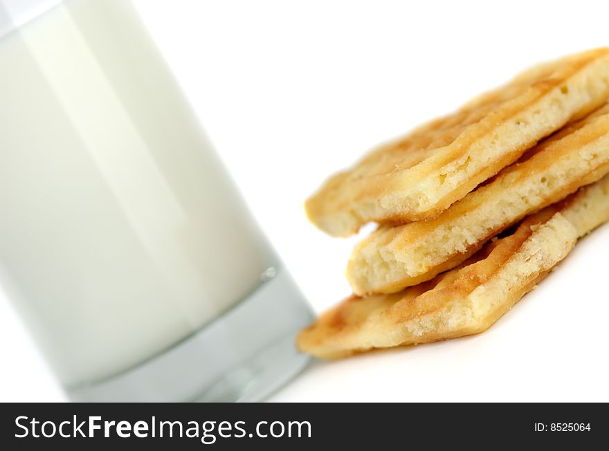 Glass of fresh milk and cookies on a white background