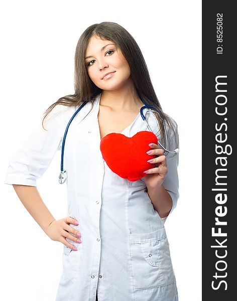 Young beautiful female cardiologist with a heart shaped pillow