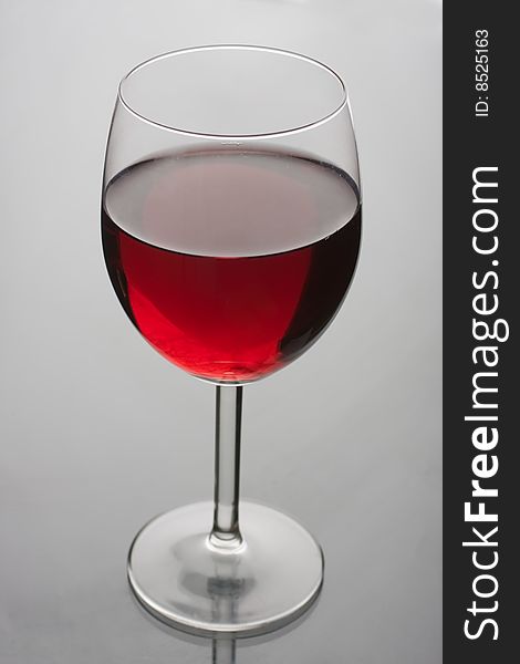 Glass of red wine on glass background