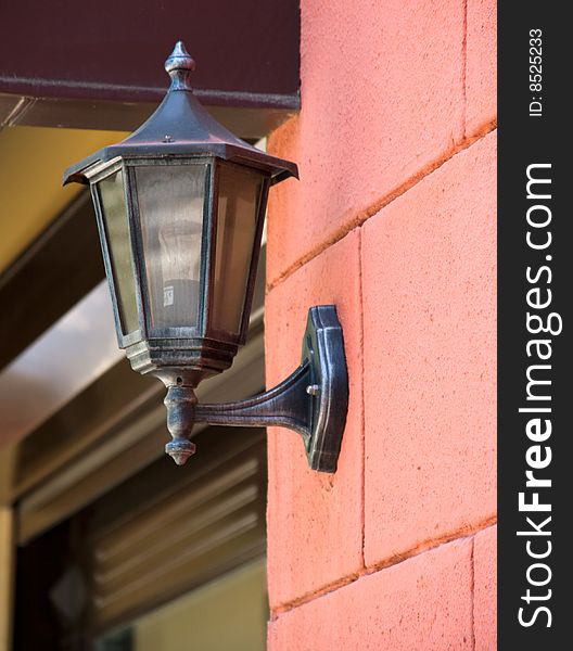 Old fashioned street lamp on a red brick wall