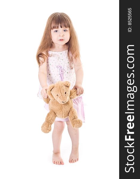 Standing little girl plays toy bear. Standing little girl plays toy bear