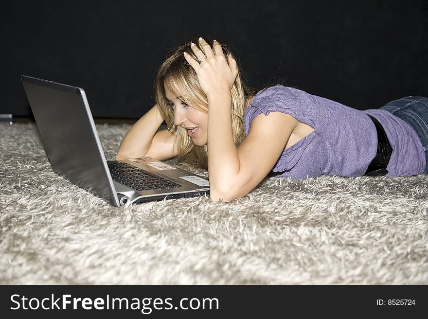 Woman laying down and working on a laptop computer at home. Woman laying down and working on a laptop computer at home