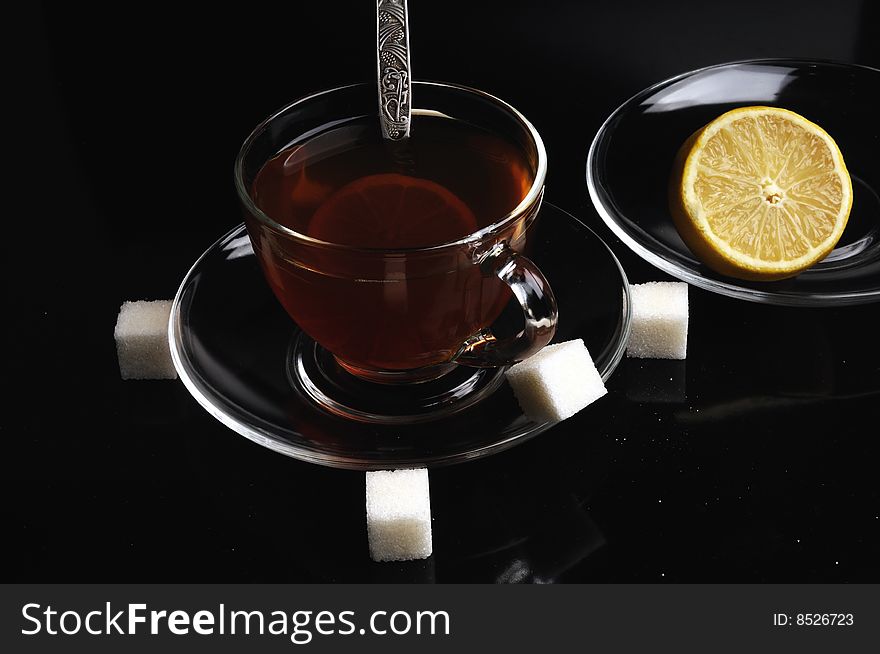 A glass cup of tea with a lemon and sugar. A glass cup of tea with a lemon and sugar