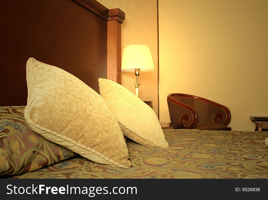 Golden classic lamp on the table near the bed in suite