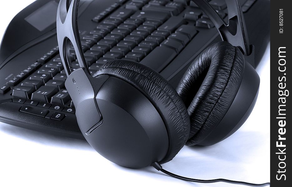 Close up of keyboard and headphones on white background