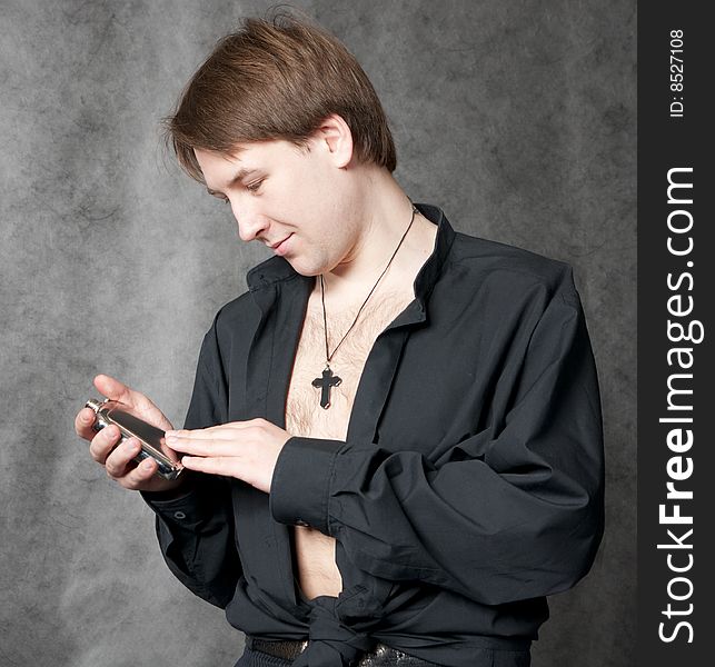 Young man in black lookng at alcohol flask. Young man in black lookng at alcohol flask