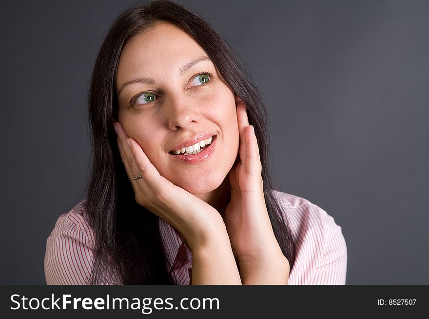 Smiling woman closeup portrait over gray in studio. Smiling woman closeup portrait over gray in studio