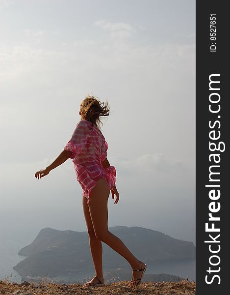 Young girl on the edge of a high cliff, wind blowing, Kefalonia (Cephalonia)Island, Greece. Young girl on the edge of a high cliff, wind blowing, Kefalonia (Cephalonia)Island, Greece