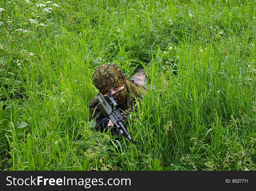Soldier with assault rifle lying in the grass. Soldier with assault rifle lying in the grass