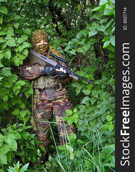 Standing soldier with assault rifle on the nature. Standing soldier with assault rifle on the nature