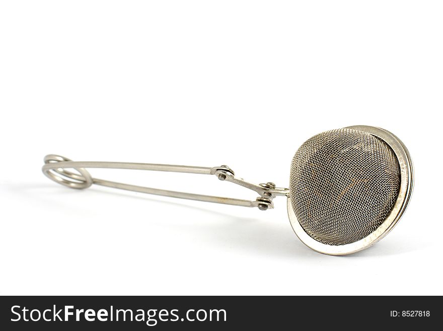 Tea strainer with tea inside isolated on white.