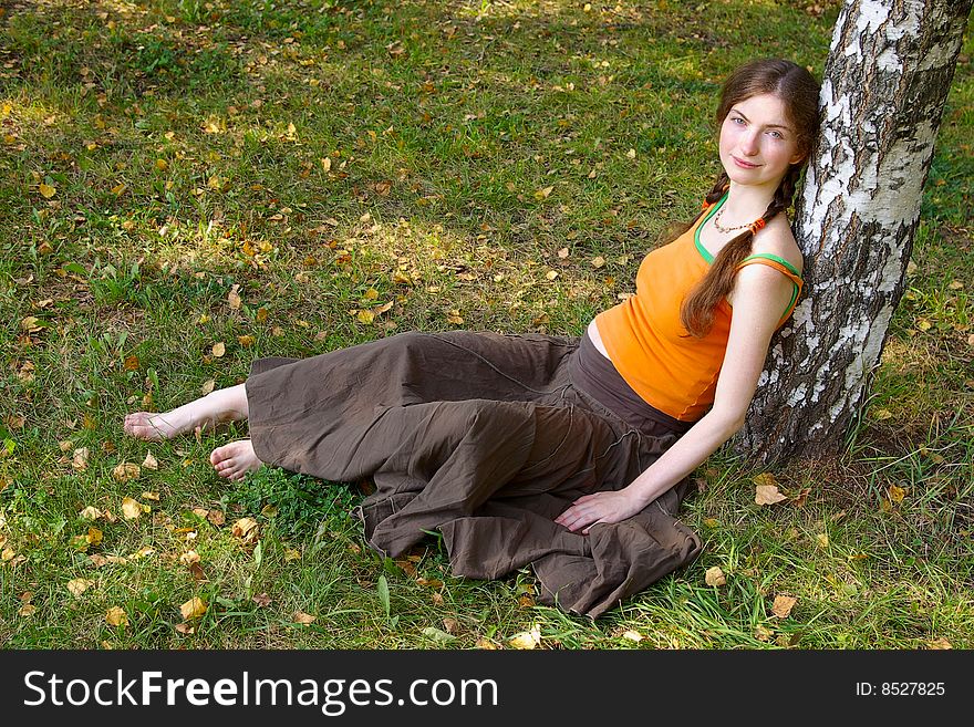 Pregnant girl sitting under a tree