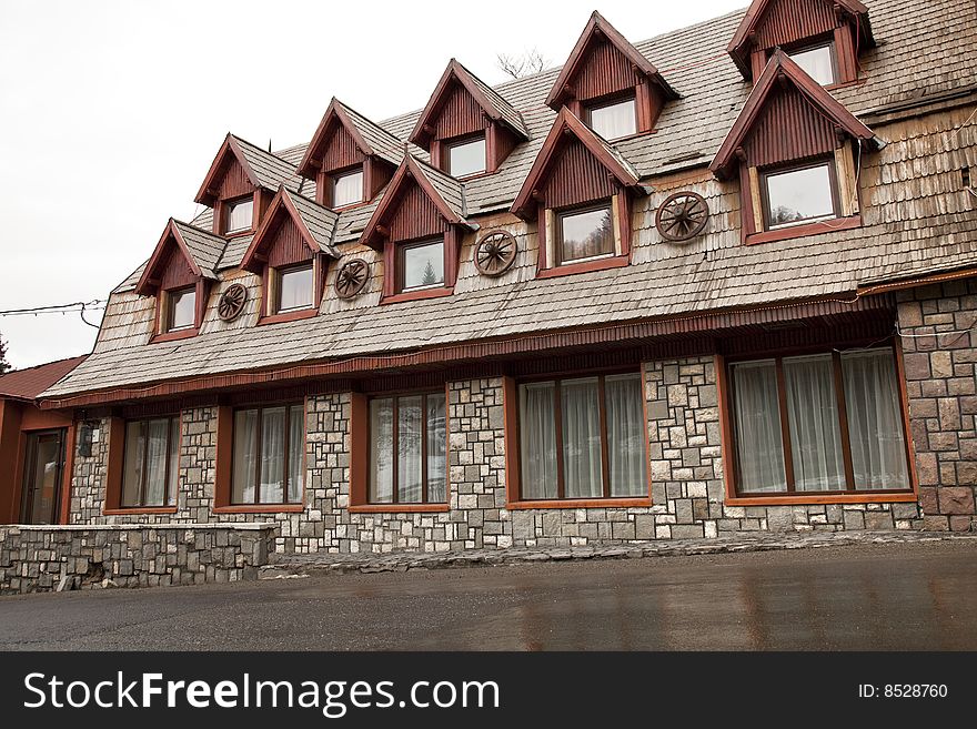 Rustic hotel made of stone with many attics