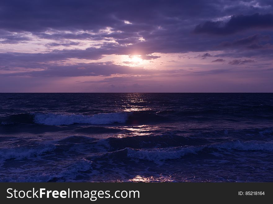 Photo of Blue Ocean and Dark Clouds during Sunset