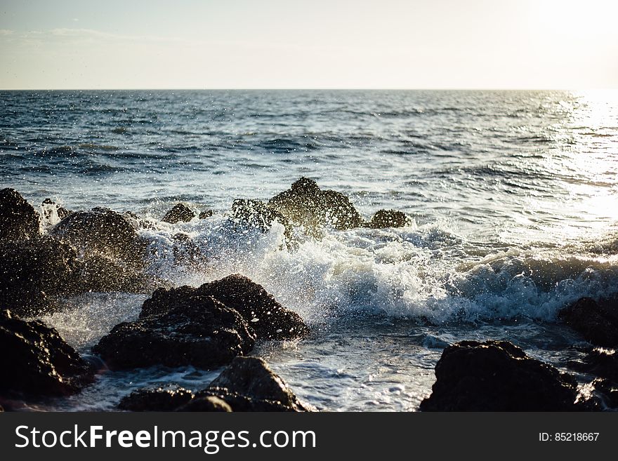 Photo Of Blue Ocean Wave Coming To The Rocky Shore