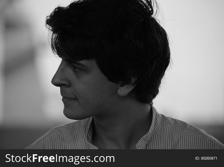 Black and white side portrait of sad handsome young man,