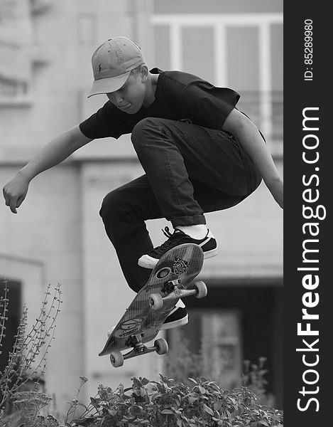 A black and white photo of a young man doing a skateboard jump.