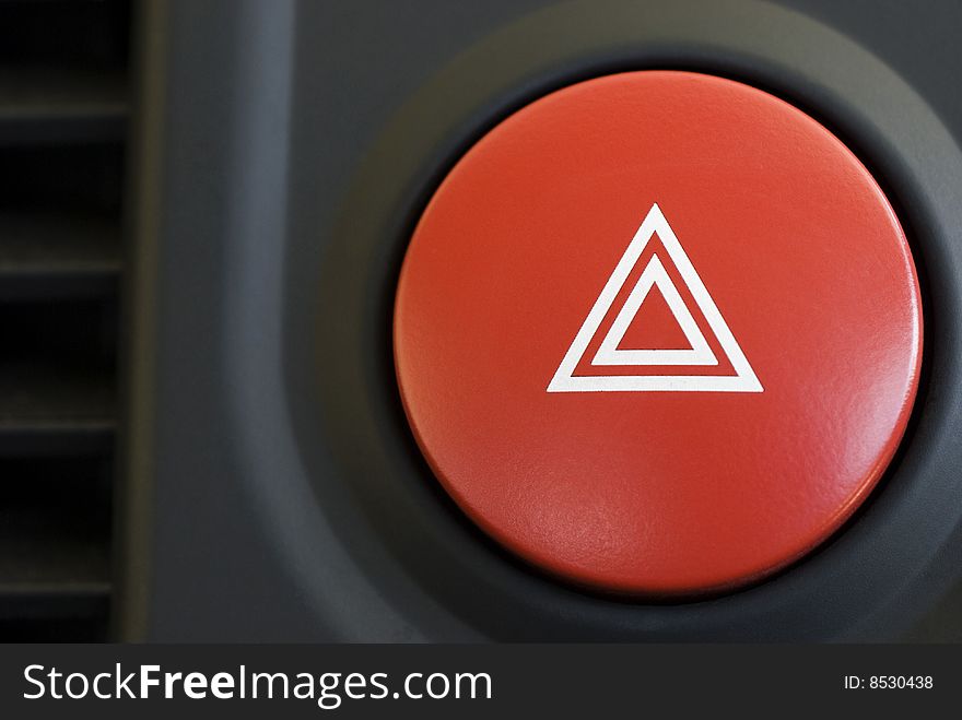 A hazard warning flasher button from a car dashboard. A hazard warning flasher button from a car dashboard