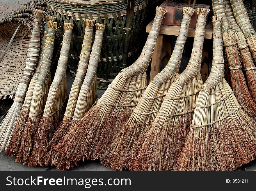 Small handmade straw brooms with crooked handles are displayed for sale in front of a local hardware store in Pengzhou, Sichuan province, China - Lee Snider Photo. Small handmade straw brooms with crooked handles are displayed for sale in front of a local hardware store in Pengzhou, Sichuan province, China - Lee Snider Photo.