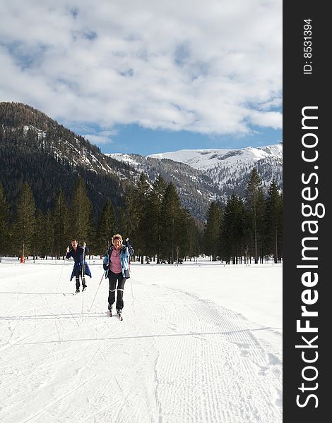 A senior couple outdoor doing cross country skiing in a winter setting. A senior couple outdoor doing cross country skiing in a winter setting.