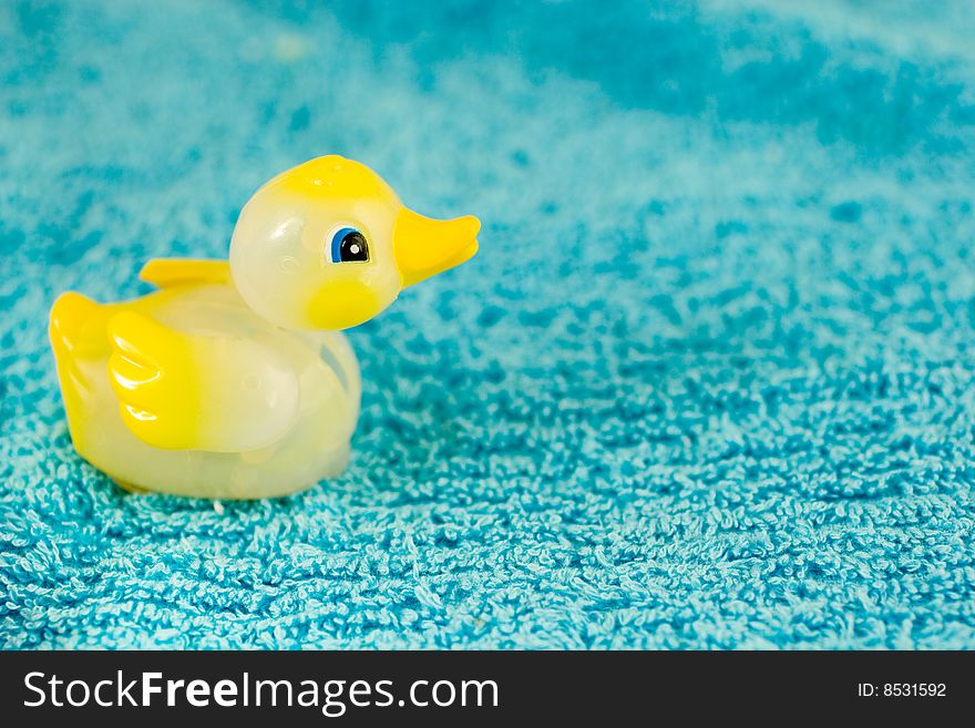 Yellow plastic ducky toy on a blue towel