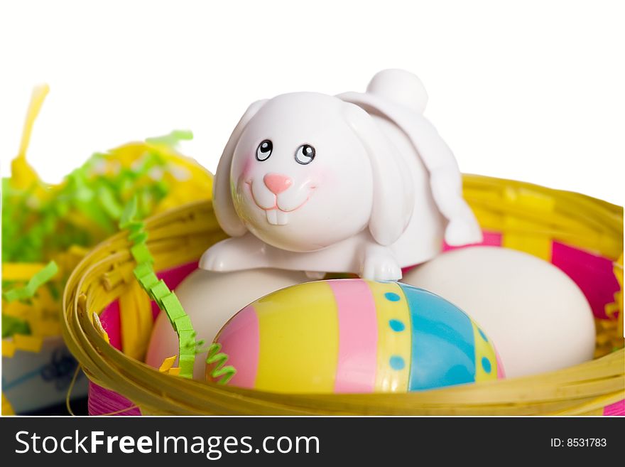 White Easter bunny in a basket with eggs, isolated on white