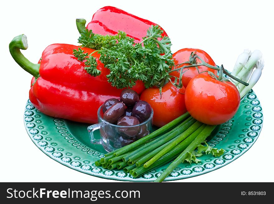 Red bell peppers, tomatoes, green onions and olives on a green plate, isolated on white. Red bell peppers, tomatoes, green onions and olives on a green plate, isolated on white