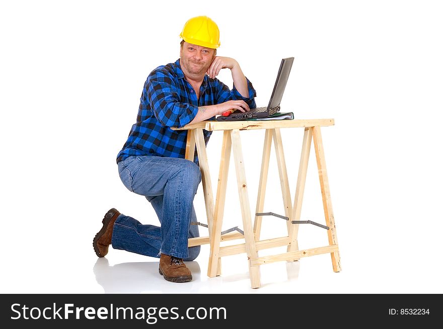Carpenter at work with laptop on white background, reflective surface, studio shot